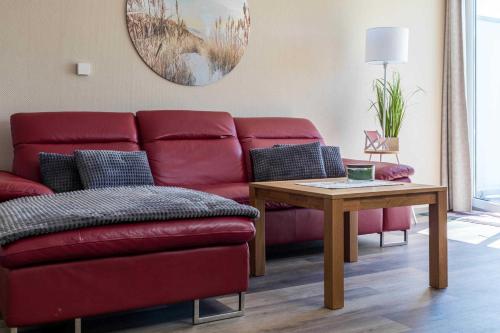 a living room with a red couch and a table at Haus Seeblick Wohnung 16 in Wohlenberg
