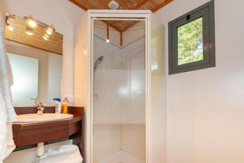 ein Bad mit einer Dusche und einem Waschbecken in der Unterkunft Camping de La Vernhe in Saint-Amans-des-Cots