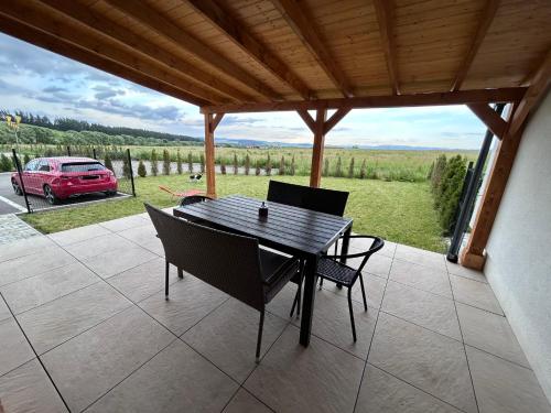 a table and chairs on a patio with a view of a car at Vila Luxury in Nová Lesná