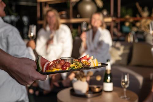a person holding a tray of fruit on a plate at Hotell Lappland in Lycksele