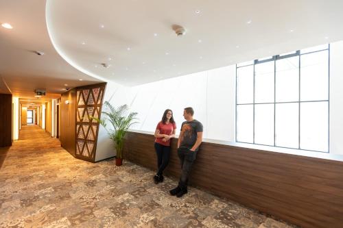 a man and a woman standing in a lobby at HOTEL CRYSTAL WELLNESS & SPA superior in Sovata