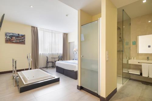 um quarto de hotel com casa de banho com banheira e chuveiro em Alda Route 42 em Illescas
