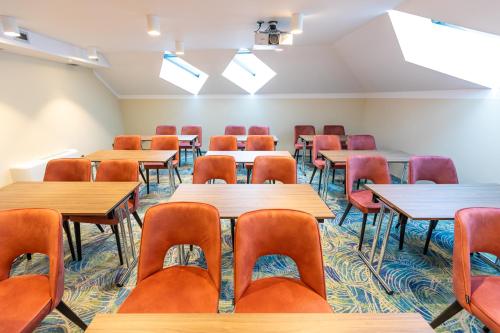 an empty classroom with tables and chairs at HOTEL CRYSTAL WELLNESS & SPA superior in Sovata