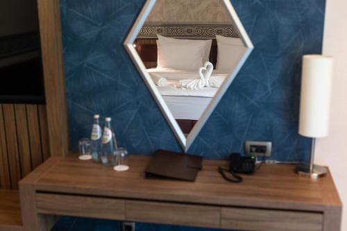 a room with a bed with a mirror on a desk at HOTEL CRYSTAL WELLNESS & SPA superior in Sovata