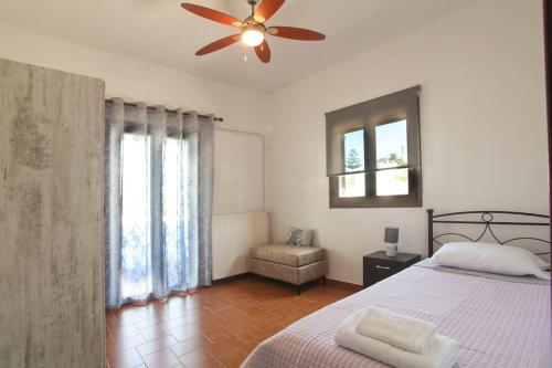 um quarto com uma cama e uma ventoinha de tecto em Μονοκατοικία με θέα τη Χώρα em Skiros