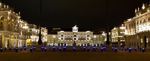 a large building with blue lights at night at B&B Gasiso in Monfalcone