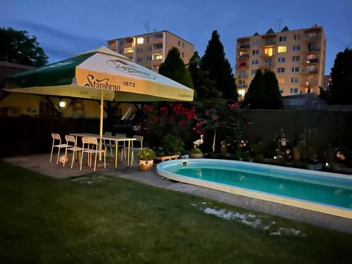 a patio with an umbrella and a table and chairs next to a pool at Ubytovani Na Hrazi 91 in Znojmo
