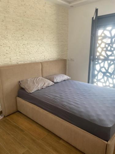 a bed sitting in a room with a window at Villa Aziza piscine privée in Oujda