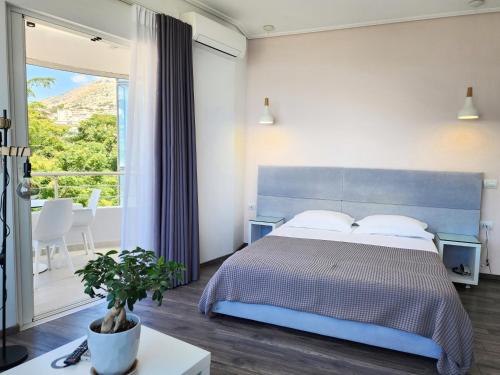 a bedroom with a blue bed and a large window at Hotel JoAn in Sarandë