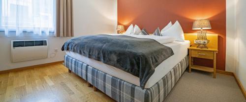 a large bed in a hotel room with a window at Seehaus Verena in Weissensee