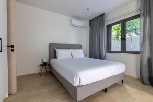 um quarto com uma cama branca e uma janela em Greyt Apartments Glyfada em Atenas
