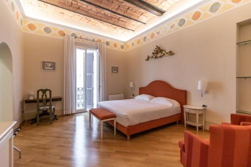 ボローニャにあるカーサ イゾラーニ ピアッツァ マッジョーレのベッドルーム1室(ベッド1台、テーブル、椅子付)