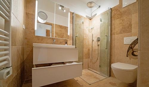 a bathroom with a shower and a toilet and a sink at Seehaus Verena in Weissensee