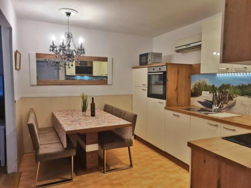 a kitchen and dining room with a table and chairs at Holiday Place Veli Dvor - vacation house with private garden in old town Punat in Punat