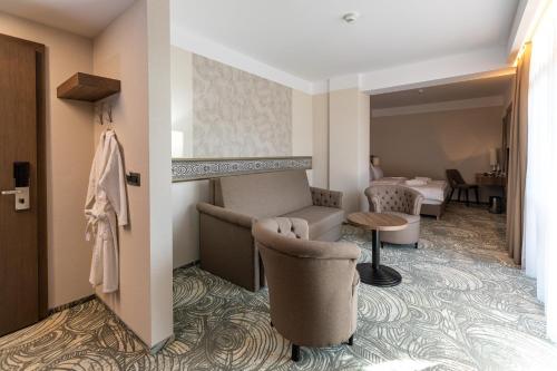 a hotel room with a couch and a table at HOTEL CRYSTAL WELLNESS & SPA superior in Sovata
