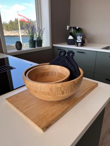 a wooden bowl on a cutting board on a kitchen counter at Korshamn Rorbuer in Lyngdal