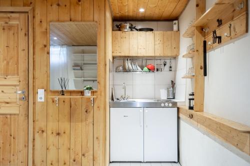 a kitchen with wooden walls and a sink and a refrigerator at City Statement Basement Studio in Tallinn
