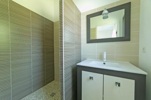een badkamer met een wastafel en een douche met een spiegel bij Villa Blanca - Maison climatisée piscine privée in Saint-Selve