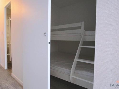 um beliche branco com uma escada num quarto em Studio Piau-Engaly, 1 pièce, 5 personnes - FR-1-457-175 em Aragnouet