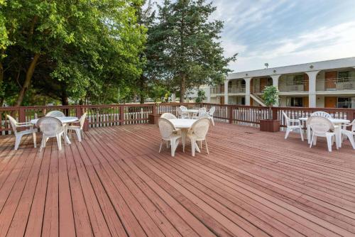 a deck with tables and chairs on a building at Super 8 by Wyndham Williamsburg/Historic Area in Williamsburg