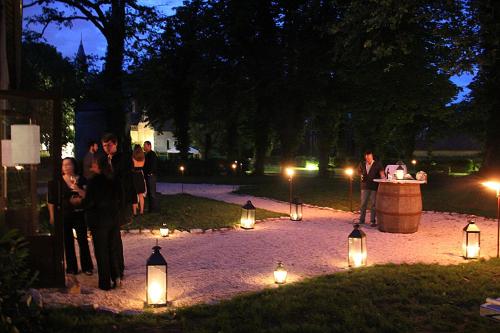 a group of people standing in a park with lights at Château - Hôtel Le Sallay in Magny-Cours