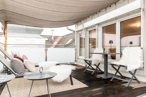 a living room with white chairs and a table at Hotel Sandwirth in Klagenfurt