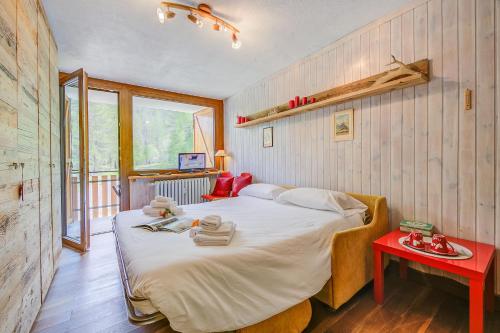 Un dormitorio con una cama grande y una mesa roja. en Studio Abete Rosso 500m From Ski - Happy Rentals en Sauze dʼOulx