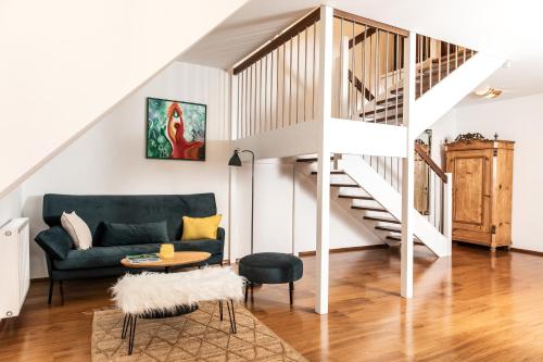 a living room with a green couch and stairs at Hotel Sandwirth in Klagenfurt