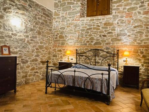 a bedroom with a bed in a stone wall at Agriturismo Tramonti in Castiglione di Garfagnana