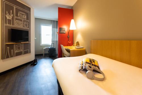 una camera d'albergo con un letto con uno zaino sopra di ibis Leuven Centrum a Lovanio
