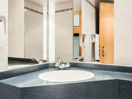 a bathroom with a sink and a mirror at ibis Lincoln in Lincoln