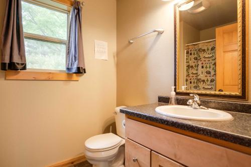 a bathroom with a sink and a toilet and a mirror at Lakefront Wisconsin Cabin Dock, Walk to Beach! 