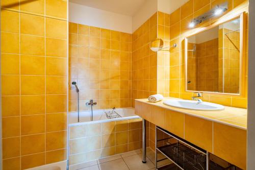 une salle de bain avec un lavabo, une baignoire et un miroir dans l'établissement The Good Mother - Vue sur Notre Dame de la Garde, à Marseille