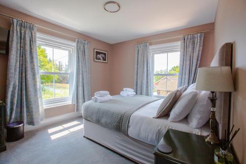 Woodfalls Inn في Redlynch: غرفة نوم بسرير ونوافذ