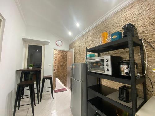 a kitchen with a refrigerator and a microwave in a room at Fullhouse in Mataram