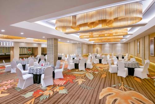 賈姆穆的住宿－Country Inn & Suites By Radisson Jammu，宴会厅配有白色的桌子和白色的椅子