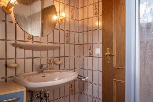 uma casa de banho com um lavatório e um espelho em 50044... em Carolinensiel