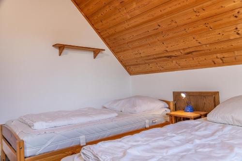 two beds in a room with a wooden ceiling at 50044... in Carolinensiel