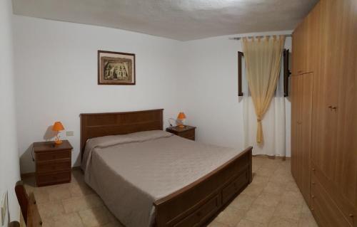 a bedroom with a large bed and two night stands at Villa Elisa Chia Su Giudeu in Domus de Maria