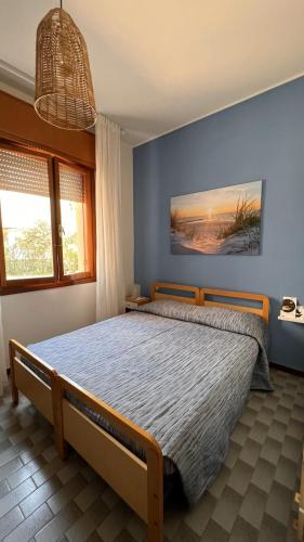 sypialnia z łóżkiem z niebieską ścianą w obiekcie Drè Marèna w Rimini