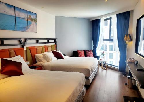 um quarto de hotel com duas camas e uma janela em APEC Mandala Cham Bay Mũi Né Condotel - Vietnam em Phan Thiet