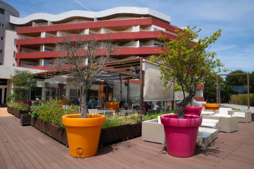 two potted trees in large pots in front of a building at MS Aparthotel in Linda-a-Velha