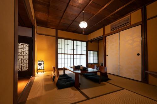 uma sala de jantar com uma mesa e cadeiras num quarto em KyoMachiya Stars em Quioto