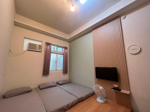 a bedroom with a bed with a fan and a window at Beauty Chen's House in Tianwei