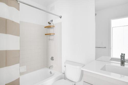 a white bathroom with a toilet and a sink at Streeterville Studio w Deck Pool nr Beach CHI-583 in Chicago