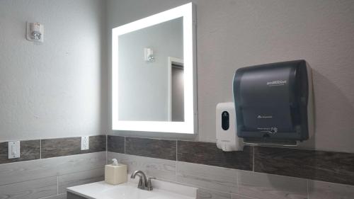 a bathroom with a soap dispenser and a mirror at Best Western Lubbock West Inn & Suites in Lubbock