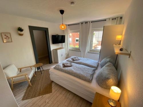 ein Schlafzimmer mit einem Bett, einem Stuhl und einem Fenster in der Unterkunft Villa Rysum in Krummhörn