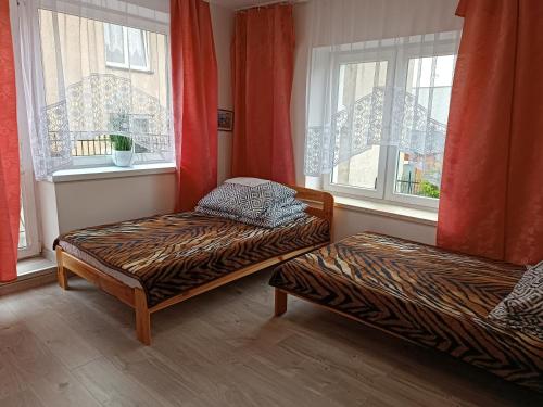 a room with two beds in front of windows at Pokoje Gościnne Heland in Jastrzębia Góra