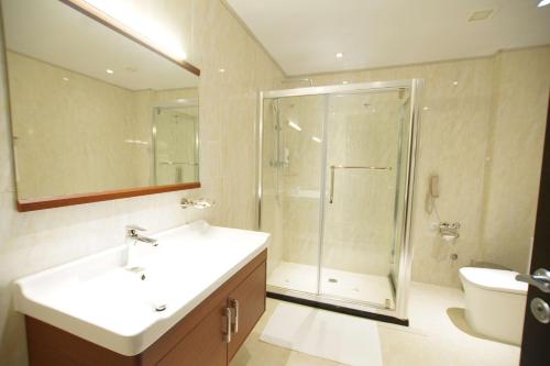 a bathroom with a shower and two sinks and a toilet at Best Western Premier Dynasty in Addis Ababa