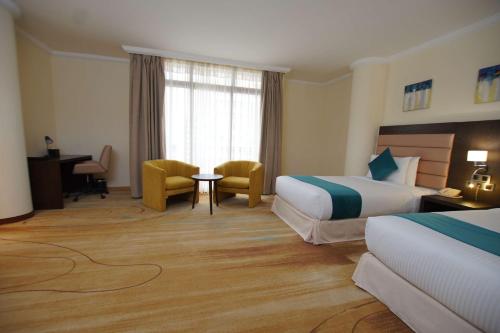 a hotel room with two beds and a desk at Best Western Premier Dynasty in Addis Ababa